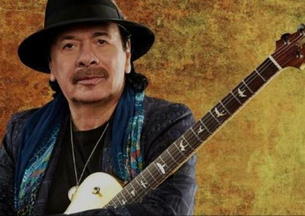 Carlos Santana en concierto sosteniendo su guitarra