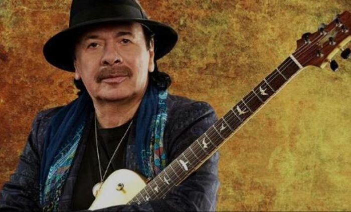 Carlos Santana en concierto sosteniendo su guitarra